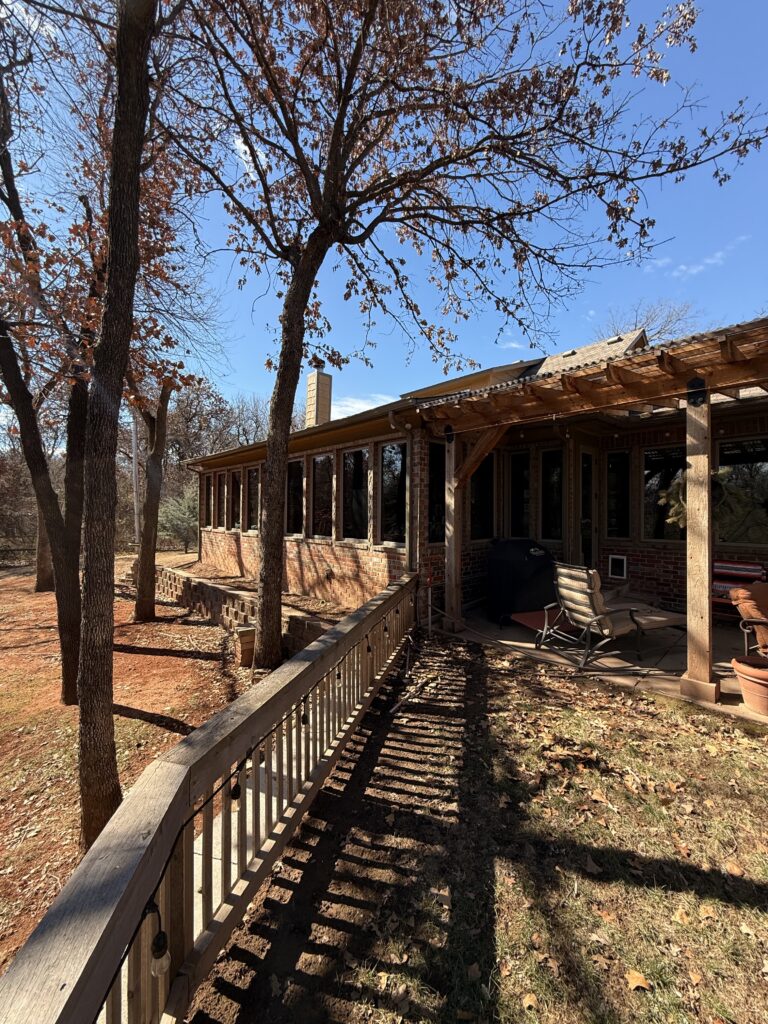 exterior cleaning and maintenance of a home with visible trees and a patio area