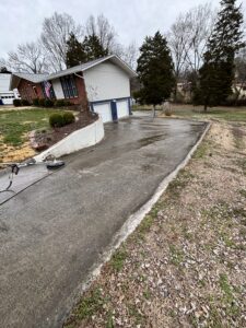 marshall's pressure washing cleaning a concrete driveway using a surface cleaner and high pressure water