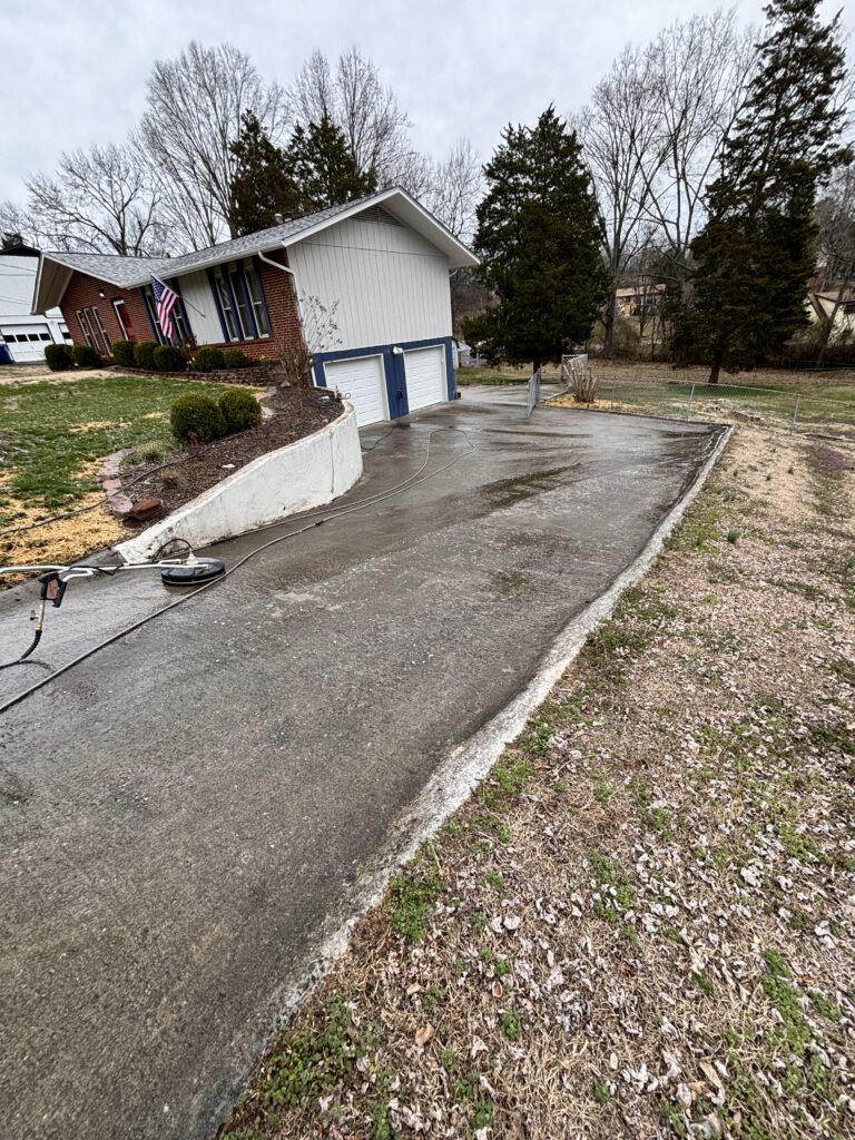 marshall's pressure washing cleaning a concrete driveway using a surface cleaner and high pressure water