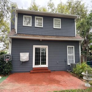 south tampa gutter and window cleaning providing services for a blue house featuring brick patio and landscaping in the yard