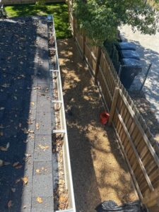 gutter cleaning service showing debris and leaves removed from gutters with a clear pathway below for drainage