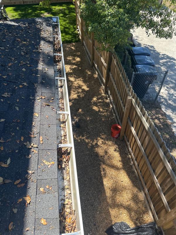 gutter cleaning service showing debris and leaves removed from gutters with a clear pathway below for drainage