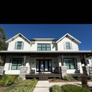 house washing service on a two story home with a worker preparing to clean the front porch area