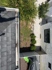 gutter cleaning service with a view of a roofline and landscaping in a residential area