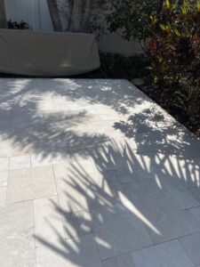 stone patio surface with shadows from nearby plants and trees creating a light and serene outdoor atmosphere