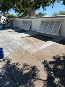 roof cleaning process with visible areas of treated surface a bucket and tool are also present in the image