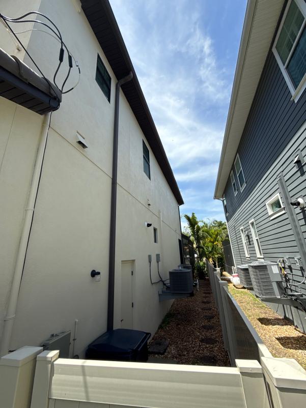 cleaning services for a residential property featuring a side view of houses and a clear sky above
