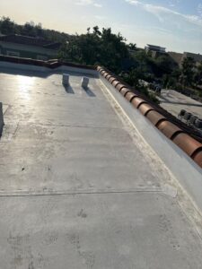 roof cleaning service with a flat surface and visible footprints near tiled edge and HVAC units in background