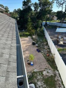 gutter cleaning service with a view of a backyard patio and surrounding greenery and landscaping features