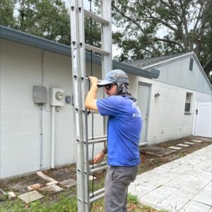 a worker from south tampa gutter and window cleaning preparing a ladder for access to a building for maintenance tasks