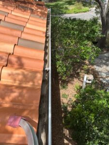 gutter cleaning service with a view of terracotta roof and surrounding greenery