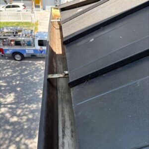 gutter cleaning service showing a dirty gutter with accumulated debris and a truck in the background