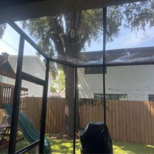 wetting down a screened enclosure with a hose to prepare for cleaning or maintenance