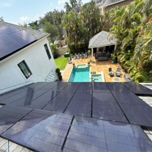 solar panel installation on a residential roof with a pool and patio visible in the backyard