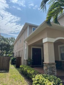 home exterior with trimmed hedges and porch under a blue sky showcasing a well-maintained property in a residential area