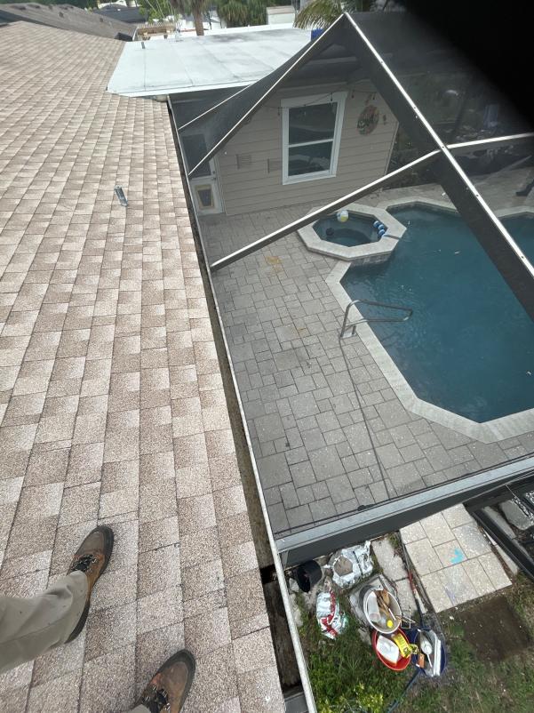 roof inspection with a view of a pool patio area and tools nearby on the ground
