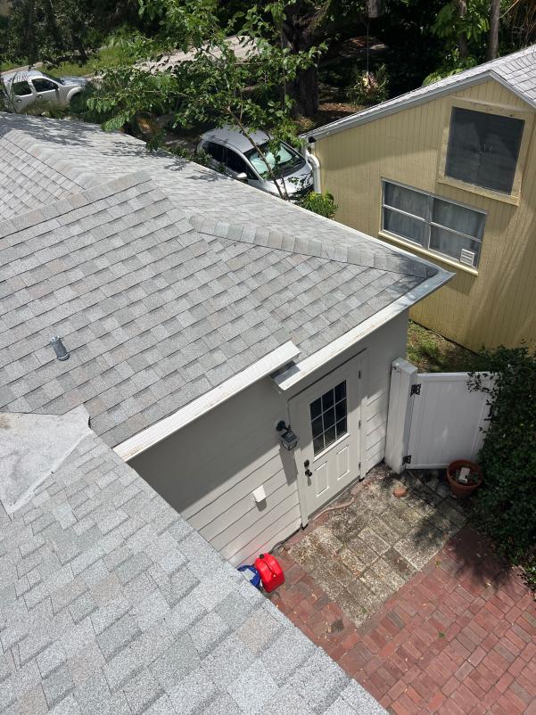 roof inspection of a residential property with gray shingles and visible landscaping around the structure
