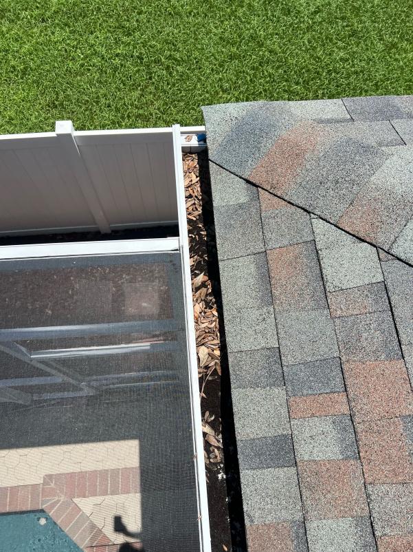 gutter cleaning near the edge of a roof with leaves and debris visible in the gutter area