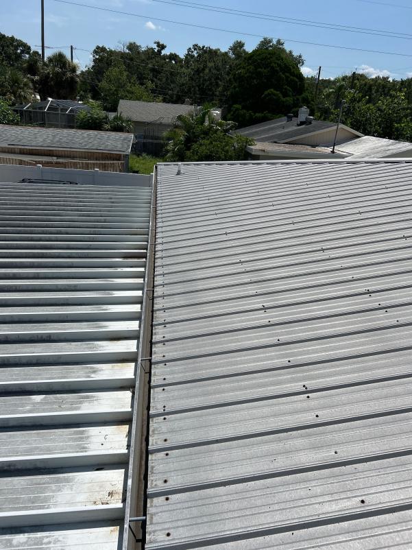 roof cleaning showing two different metal roof sections one is clean and the other has dirt and debris accumulation