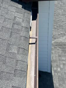 gutter cleaning service revealing a clear gutter with no debris along a sloped roofline