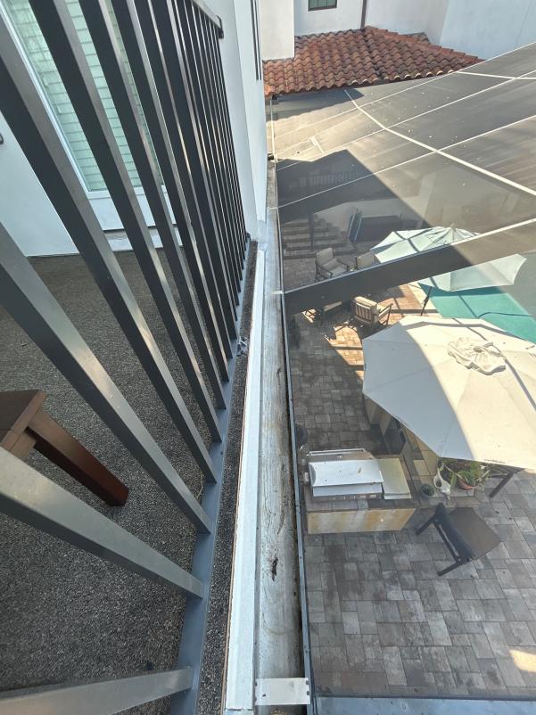 gutter cleaning service observed on balcony area with a view of patio furniture and pool area below