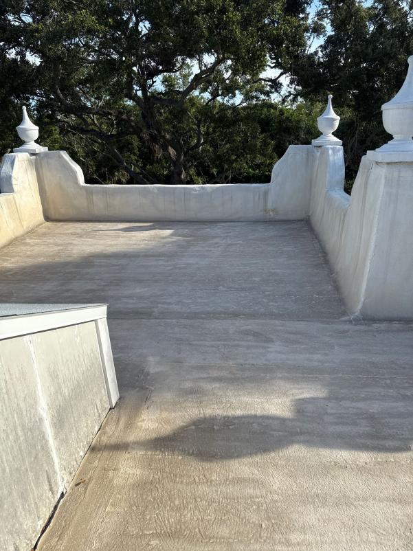 rooftop cleaning service being provided on a flat surface with visible shadows and surrounding greenery