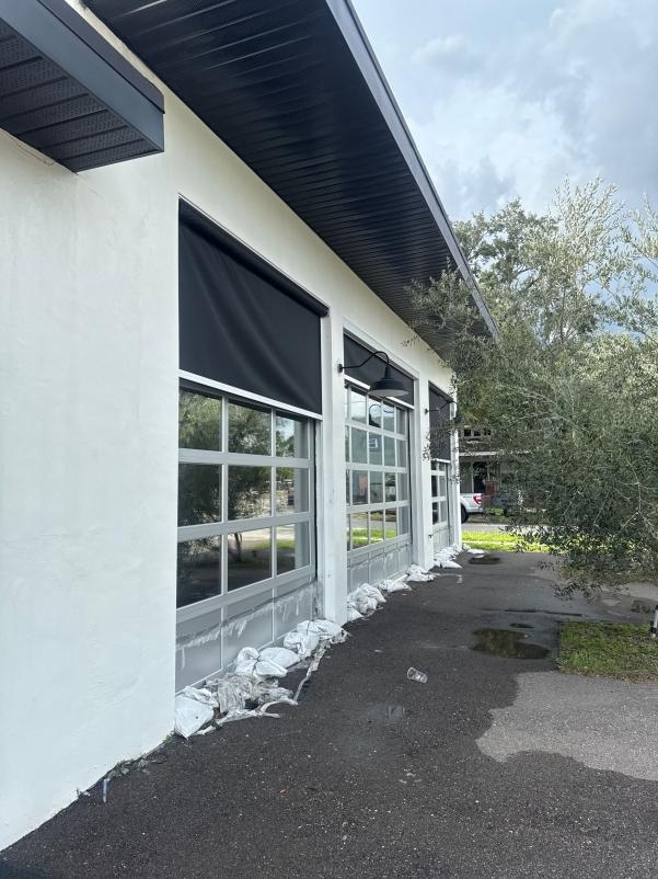 cleaning service preparing to wash walls and windows of a commercial building with protective barriers along the base