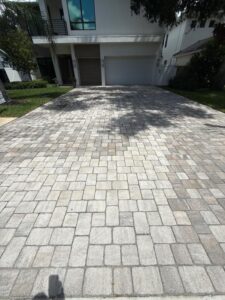 driveway cleaning service performed on a paver driveway with neat interlocking stones in a residential area