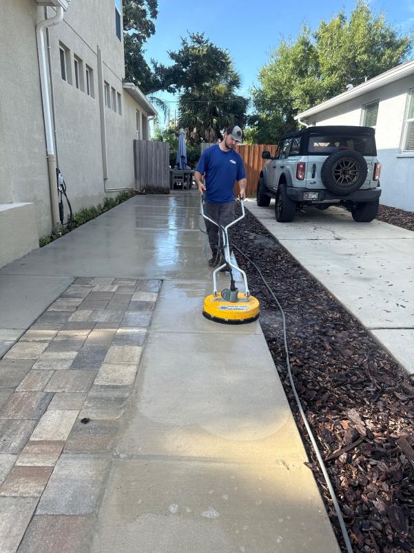 south tampa gutter and window cleaning pressure washing a concrete surface with a flat surface cleaner machine